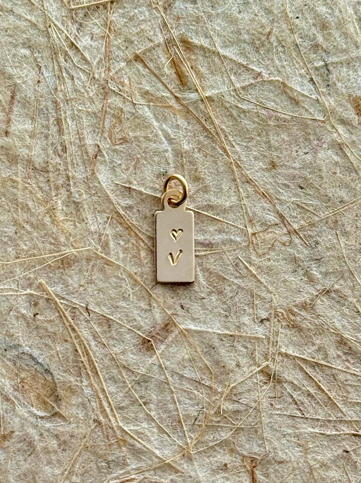 Mini Tag Initial Charm shot as a close up to see details of the mini tag charm