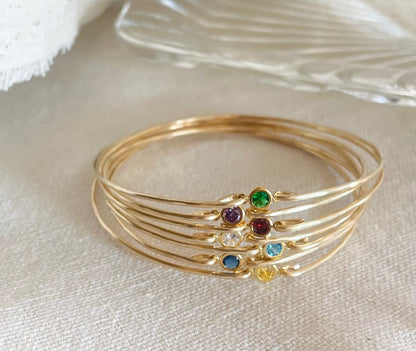 Dainty birthstone bangle featuring sparkling CZ diamonds, ideal for stacking and layering, perfect for brides, bridesmaids, and gifts. Bangles on Fabric.