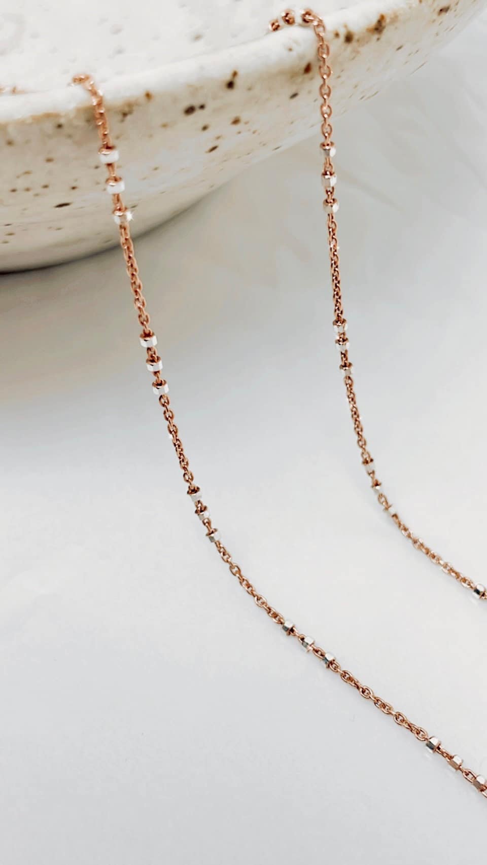 Two-tone Rose Gold and Sterling Silver satellite chain necklace featuring small silver beads spaced in sets of threes for a chic and contemporary length look. 