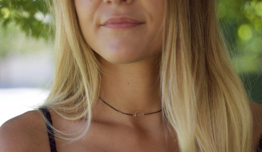 Dainty open circle choker necklace on black chain, perfect for layering with gold accessories